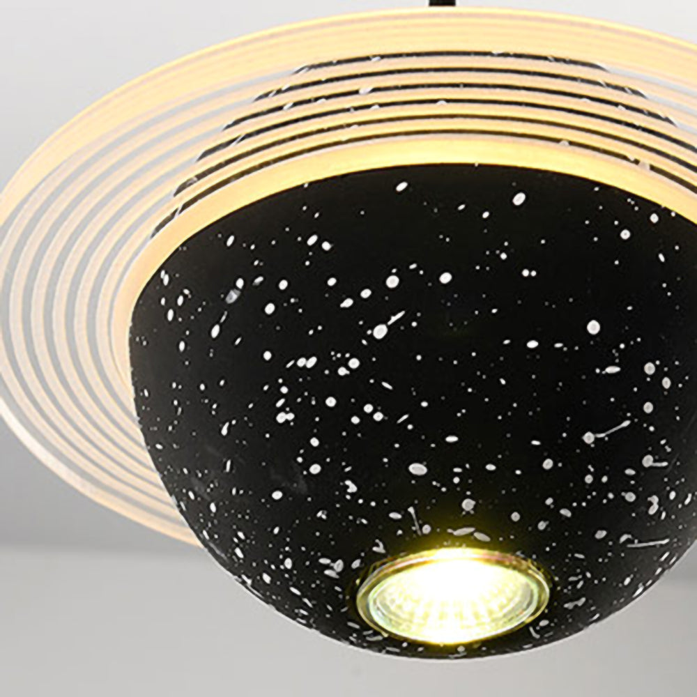 Looking up at a sand black Clérachic pendant, with a lit bulb at the base of the speckled sphere and a glowing ring around it.