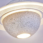 Looking up at the underside of a pale speckled Clérachic pendant, with a bright round bulb and a layered ring above.