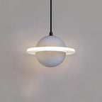Smooth pale grey Clérachic pendant with a glowing ridged ring and a faint halo, hanging against a grey wall.