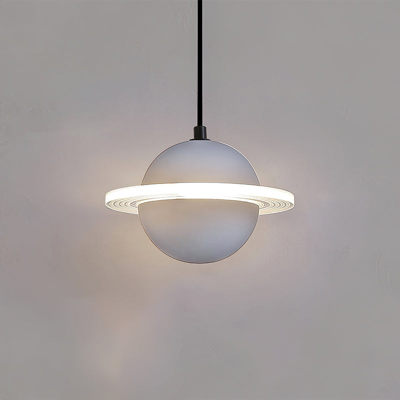 Smooth pale grey Clérachic pendant with a glowing ridged ring and a faint halo, hanging against a grey wall.