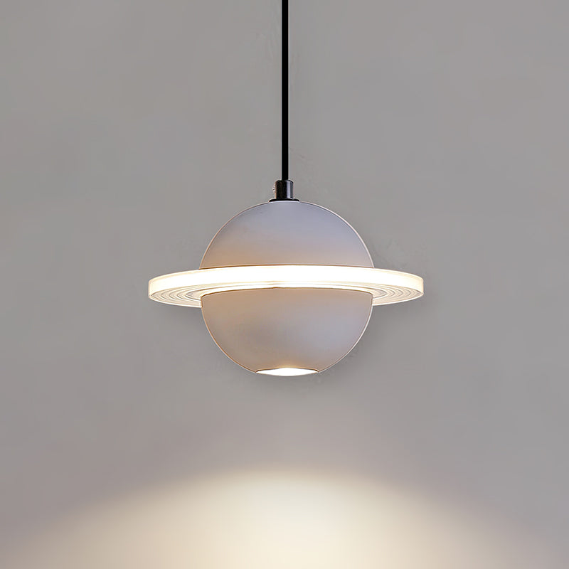 Pale grey Clérachic pendant with a lit ring and a pool of light beneath it, hanging on a black cord on a grey wall.