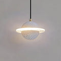 Pale grey speckled Clérachic pendant with a brass cord top and a glowing ridged ring on a grey wall.