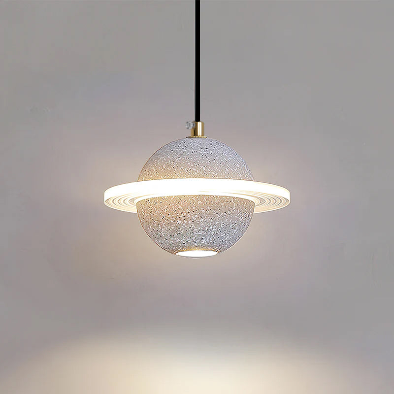 Pale speckled grey Clérachic pendant with a lit ring, and a bright pool of light on the wall below it.