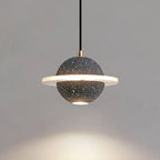 Lit sand black Clérachic pendant with a bright ring and a downlight, with a warm pool of light on the wall below.
