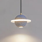 Grey blue speckled Clérachic pendant with a lit ring and a downlight, with a pool of light spreading on the wall below.