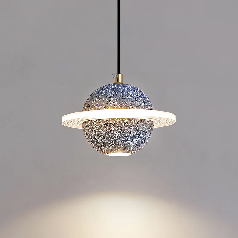 Grey blue speckled Clérachic pendant with a lit ring and a downlight, with a pool of light spreading on the wall below.