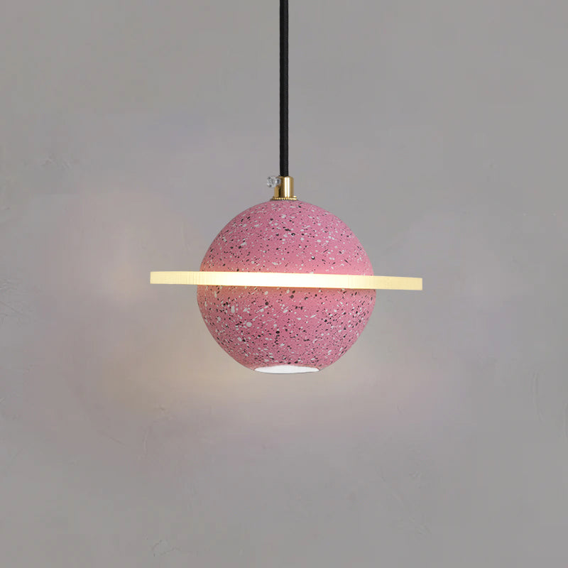 Sand pink Clérachic pendant with a flat glowing ring and a downlight, with a soft pool of light on the wall below.
