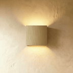 This Clérachic square wall lamp in brushed gold finish casts a soft warm glow up and down the wall.