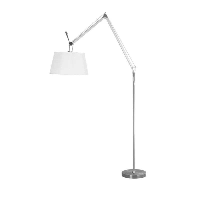 Clérachic floor lamp on a white backdrop with the shade swung to the left of its folded silver arm, above a round base.