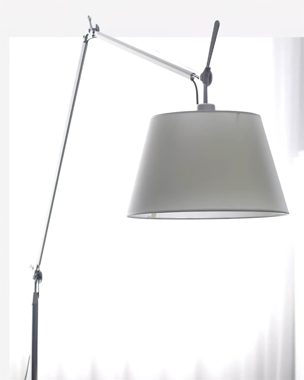 Close view of the grey fabric shade, silver arm joint and black adjusting handle on this Clérachic floor lamp.