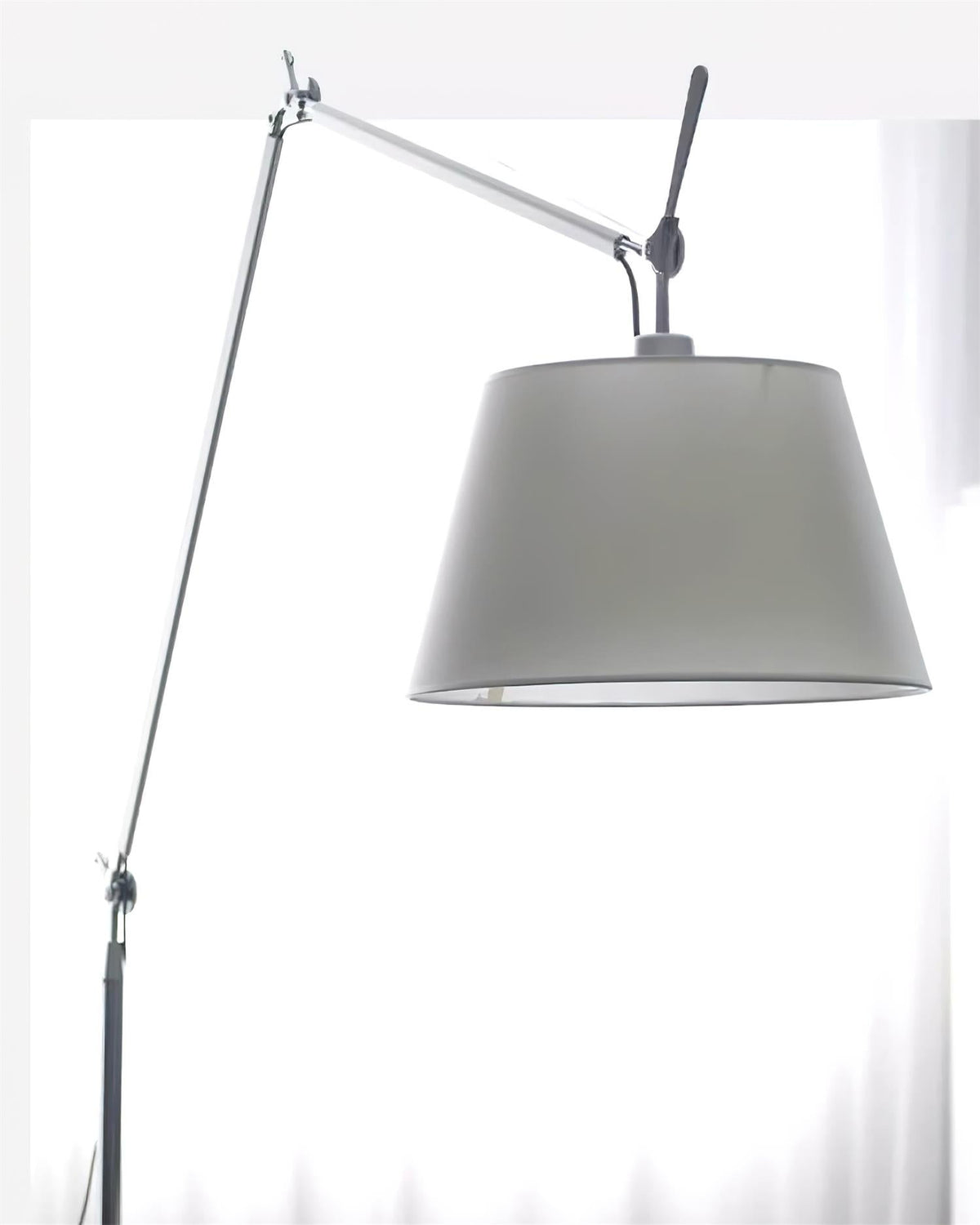 Close view of the grey fabric shade, silver arm joint and black adjusting handle on this Clérachic floor lamp.