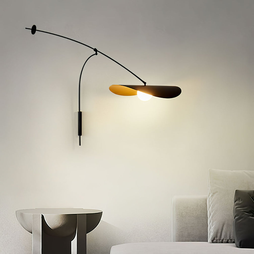 The black arm of this Clérachic wall light stretches above a light sofa, with the shade lit warm from the globe inside.