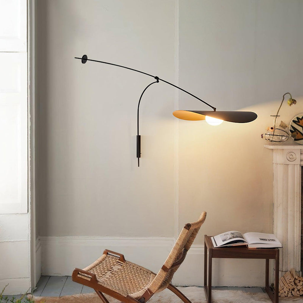 In a calm room with a wooden folding chair and open book, this Clérachic wall light glows warm from its black shade.