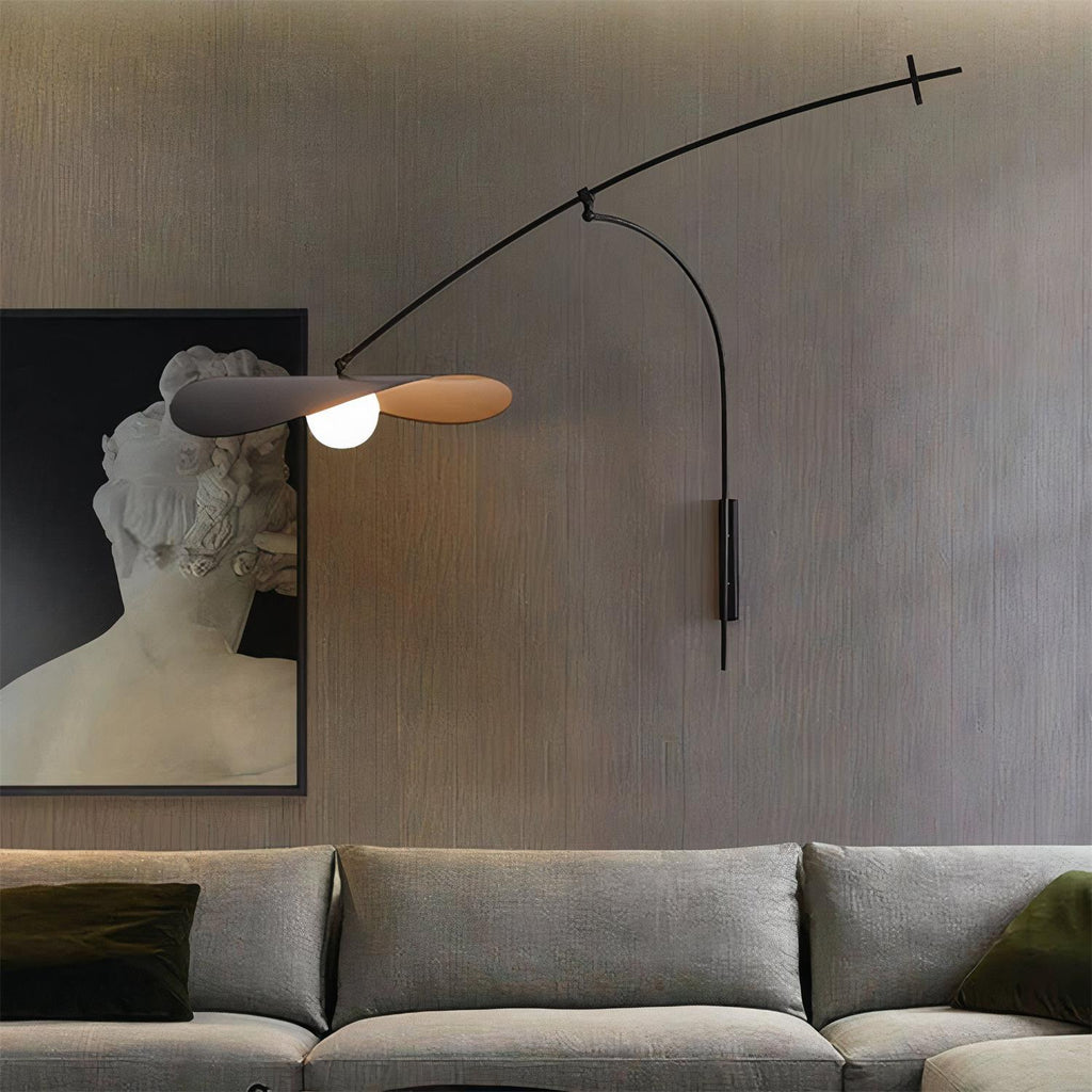 Over a grey sofa and a framed classical bust, this Clérachic wall light hangs against a dark, ribbed wall.