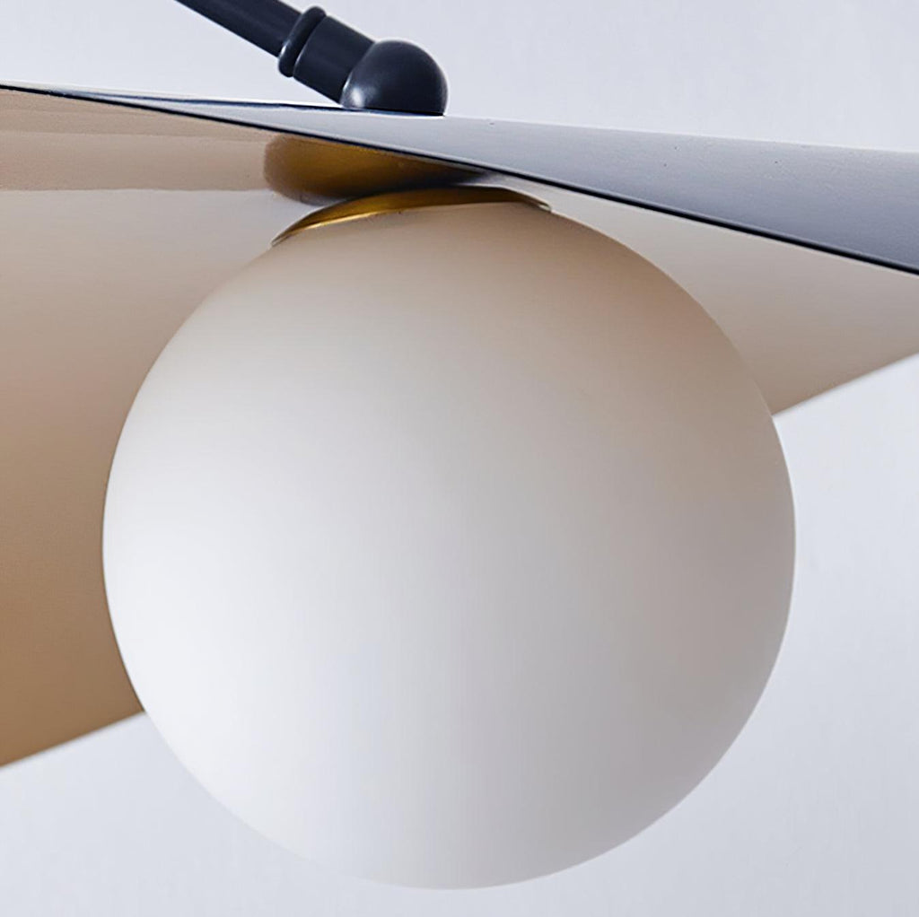 Close view of the frosted white globe on this Clérachic wall light, tucked under the black shade and its swivel joint.