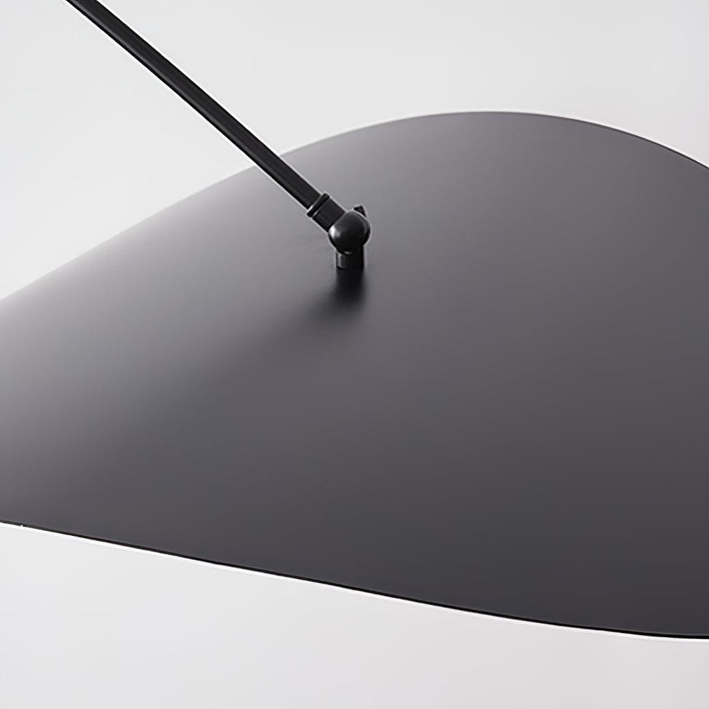 Close view of the black upper side of this Clérachic wall light's shade, with the pivot joint where the arm meets it.