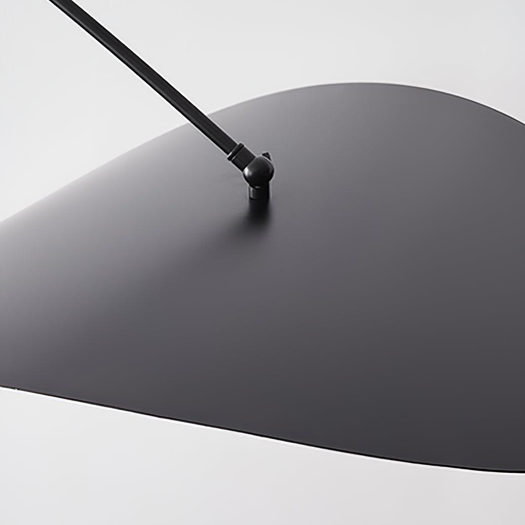 Close view of the black upper side of this Clérachic wall light's shade, with the pivot joint where the arm meets it.