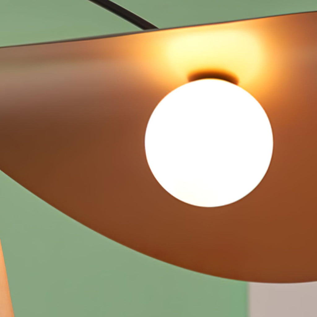 Close view of the glowing white globe on this Clérachic wall light, set in the warm copper-toned underside of the shade.