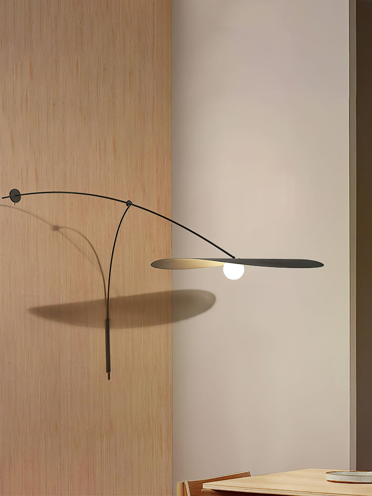 The black arm of this Clérachic wall light stretches across oak panelling, its shade casting a soft shadow.