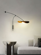 Narrow view of this Clérachic wall light above a sculptural side table and a light sofa, the shade softly lit.