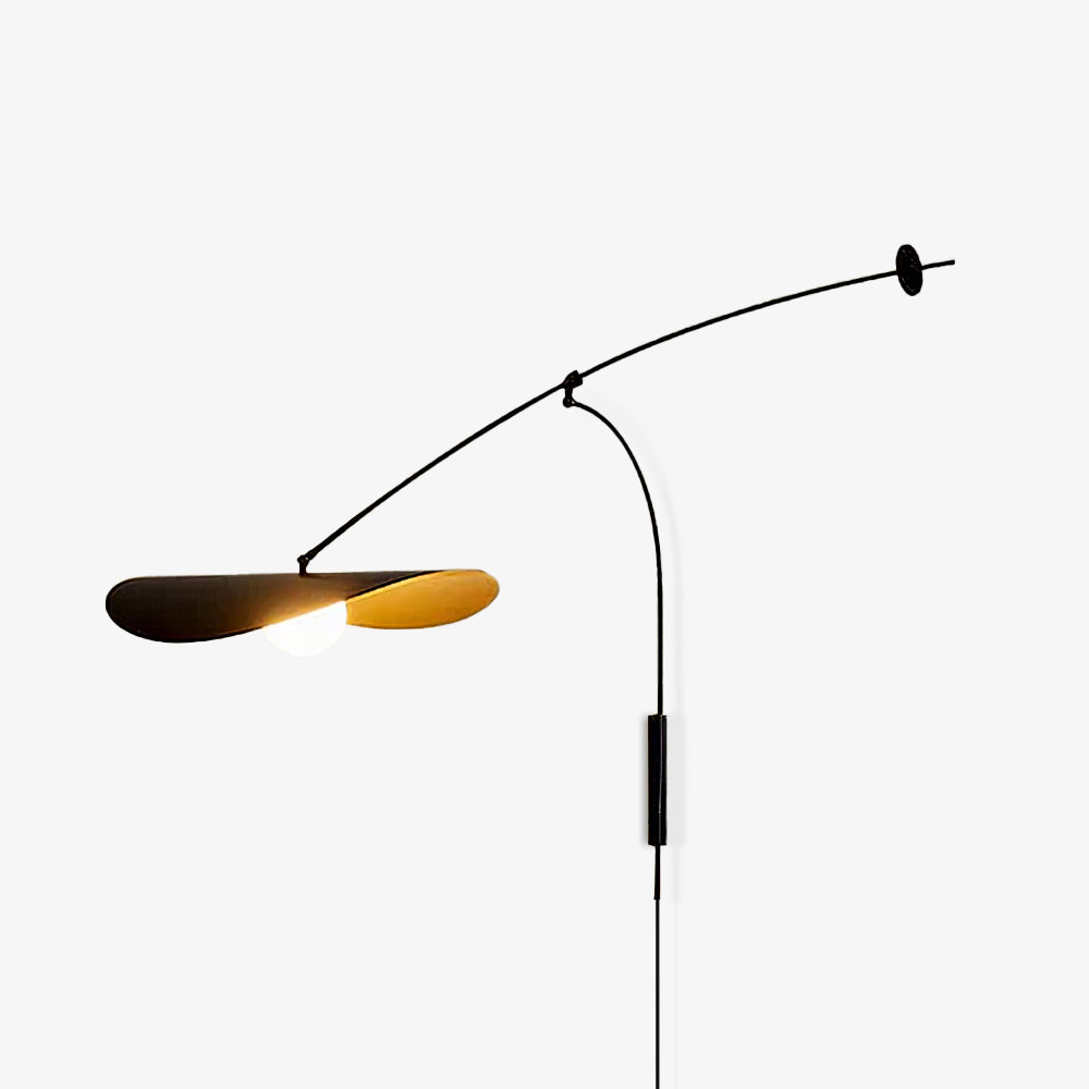 Studio shot of a Clérachic wall light on light grey, the shade tilted to show its gold-lined underside and a cord hanging down.