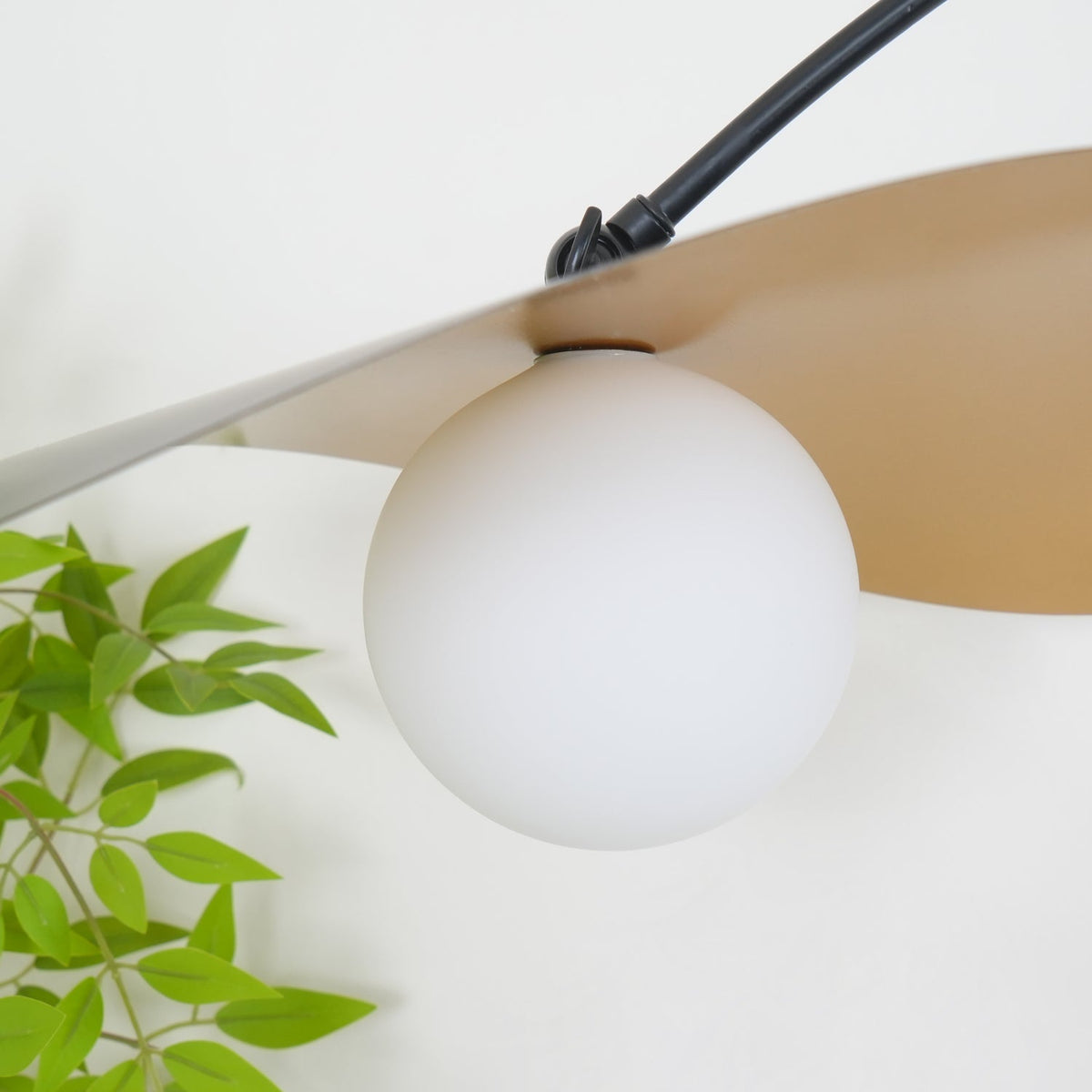 Very close view of the frosted white globe on this Clérachic wall light, set under the shade's pale underside.