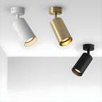 Three Clérachic ceiling spotlights in white, gold and black, each angled on its own arm beneath a white ceiling corner.