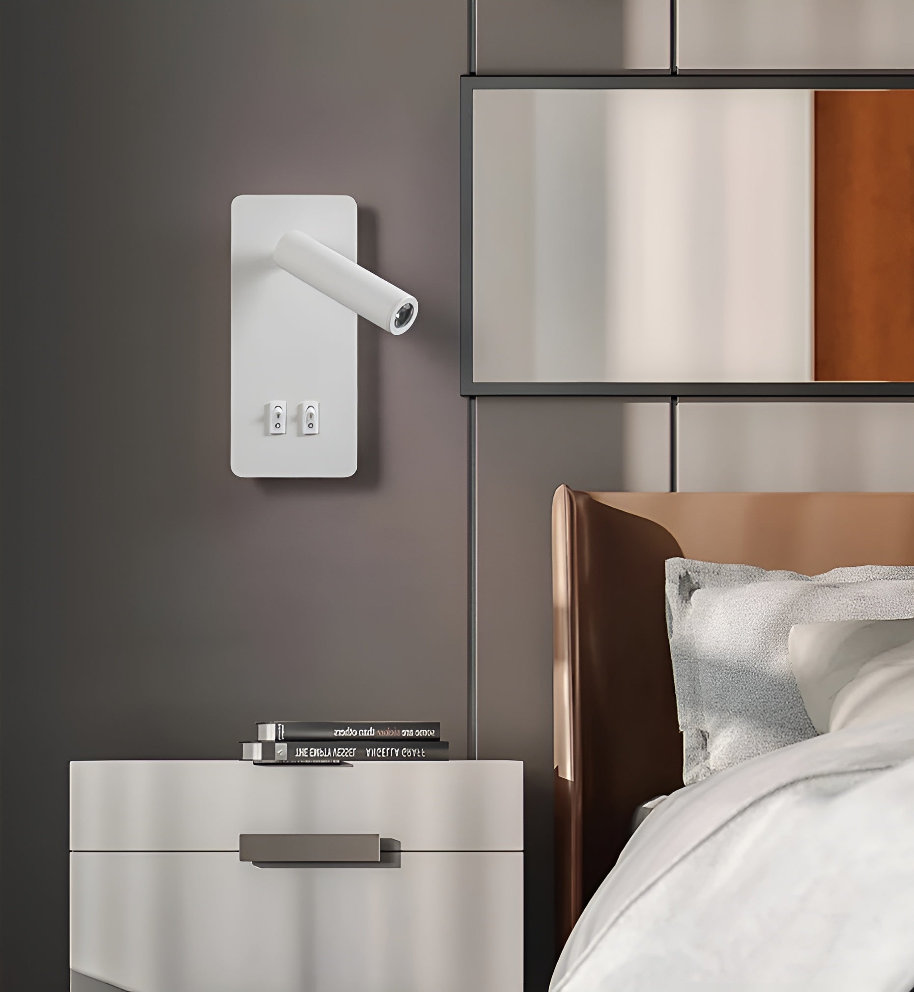Clérachic reading light in white mounted beside a bed, books stacked on the nightstand below.