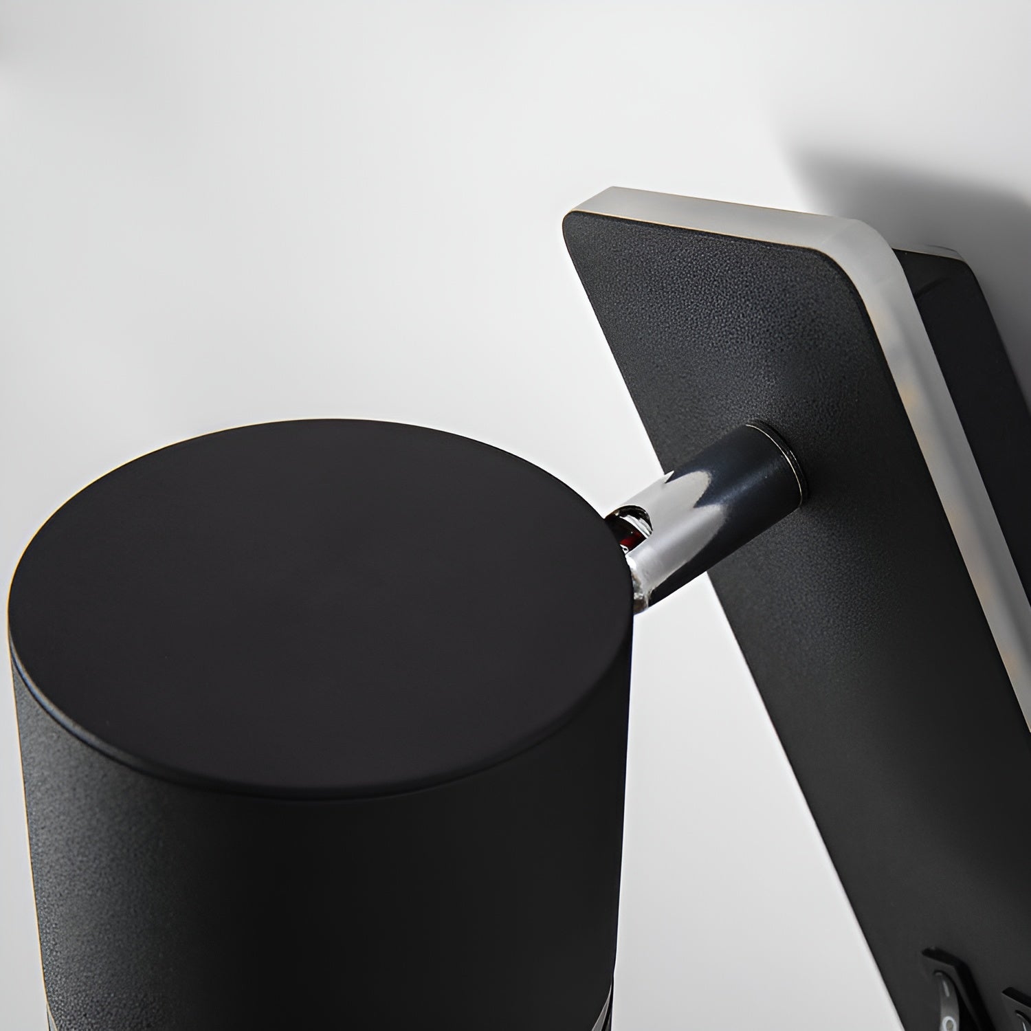 Close-up of the Clérachic reading light's rotating cylinder head and chrome swivel joint.