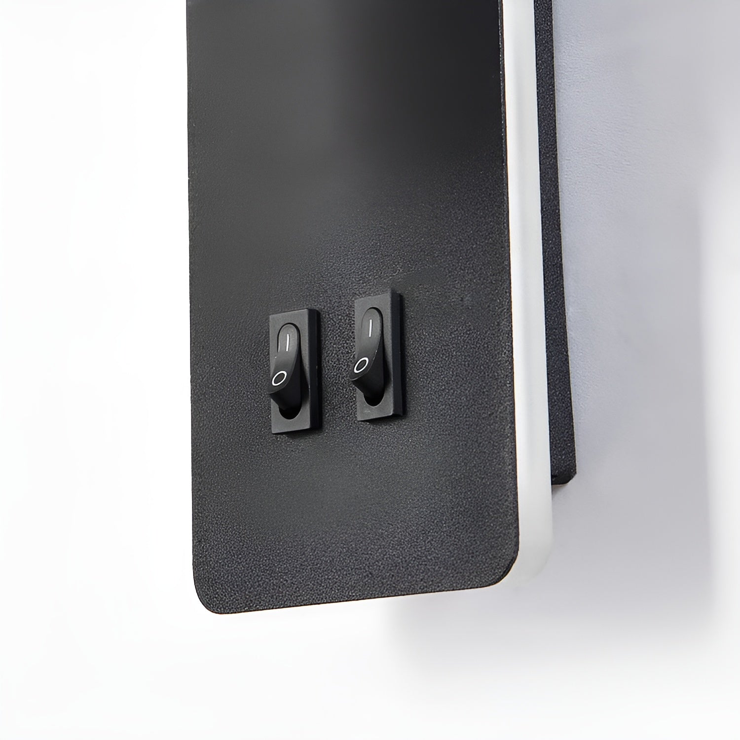 Close-up of the Clérachic reading light's two rocker switches on the black backplate.