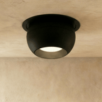 Clérachic black ball-shaped recessed downlight with a round trim and frosted lens, shown flush in a limewashed ceiling.