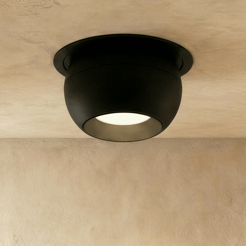 Clérachic black ball-shaped recessed downlight with a round trim and frosted lens, shown flush in a limewashed ceiling.