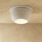 Clérachic white ball-shaped recessed downlight glowing warm from its deep reflector, set into a soft plaster ceiling.
