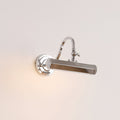 With its chrome shade turned sideways, this Clérachic wall light glows softly against a warm cream wall.