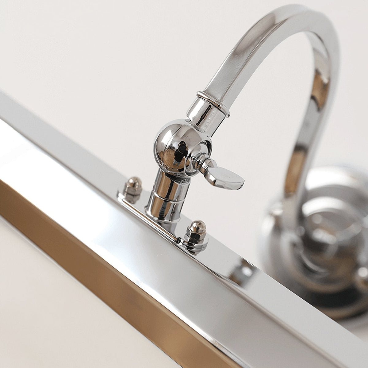 Close view of the chrome swan-neck arm, wing-screw joint and polished shade on this Clérachic wall light.
