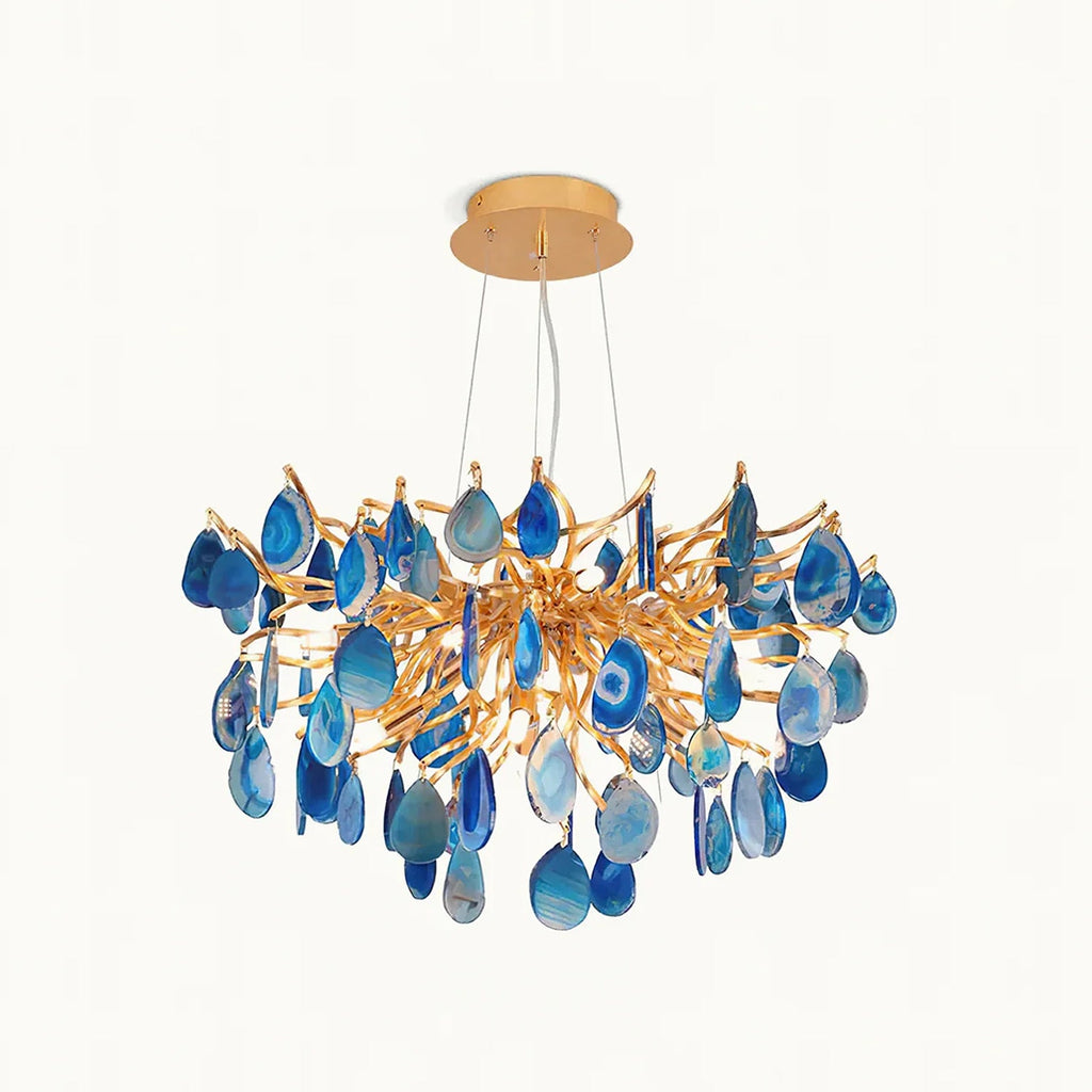 This Clérachic chandelier on a plain white backdrop, with blue agate slices hanging from a branching gold frame and a round gold canopy.