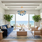 Clérachic chandelier with blue agate slices hanging in a beamed living room, with a navy sofa and a view of the sea.