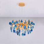 Blue agate Clérachic chandelier on a pale grey backdrop, its teardrop slices hanging below a gold branch frame.