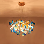 Lit blue agate Clérachic chandelier against a warm orange ceiling, light showing through the teal and blue stone slices.