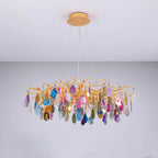 Multicolour agate Clérachic chandelier lit against a pale wall, with pink, blue and amber slices on gold branches.
