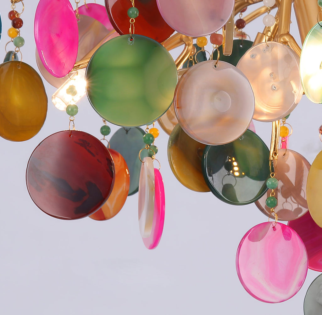 Close view of round agate discs in pink, green, plum and amber on this Clérachic chandelier, with small green beads.