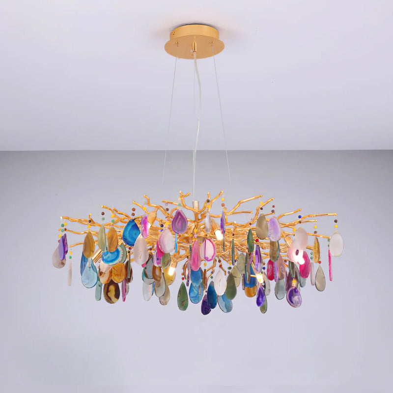 Multicolour agate Clérachic chandelier on a pale grey backdrop, with slices in blue, pink, amber and green hanging from gold branches.