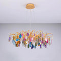 Multicolour agate Clérachic chandelier on a pale grey backdrop, with slices in blue, pink, amber and green hanging from gold branches.