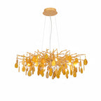 Amber agate Clérachic chandelier on a white backdrop, with honey-coloured slices hanging from a wide gold branch frame.