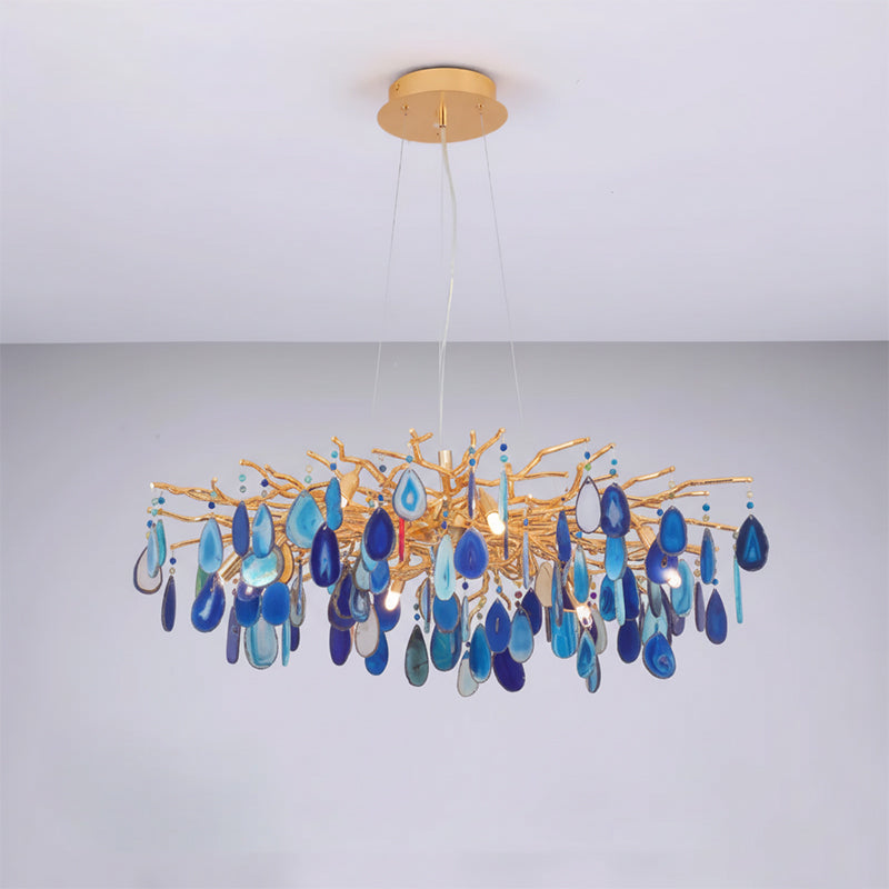 Blue agate Clérachic chandelier on a pale grey backdrop, with slices from navy to sky blue on a wide gold frame.