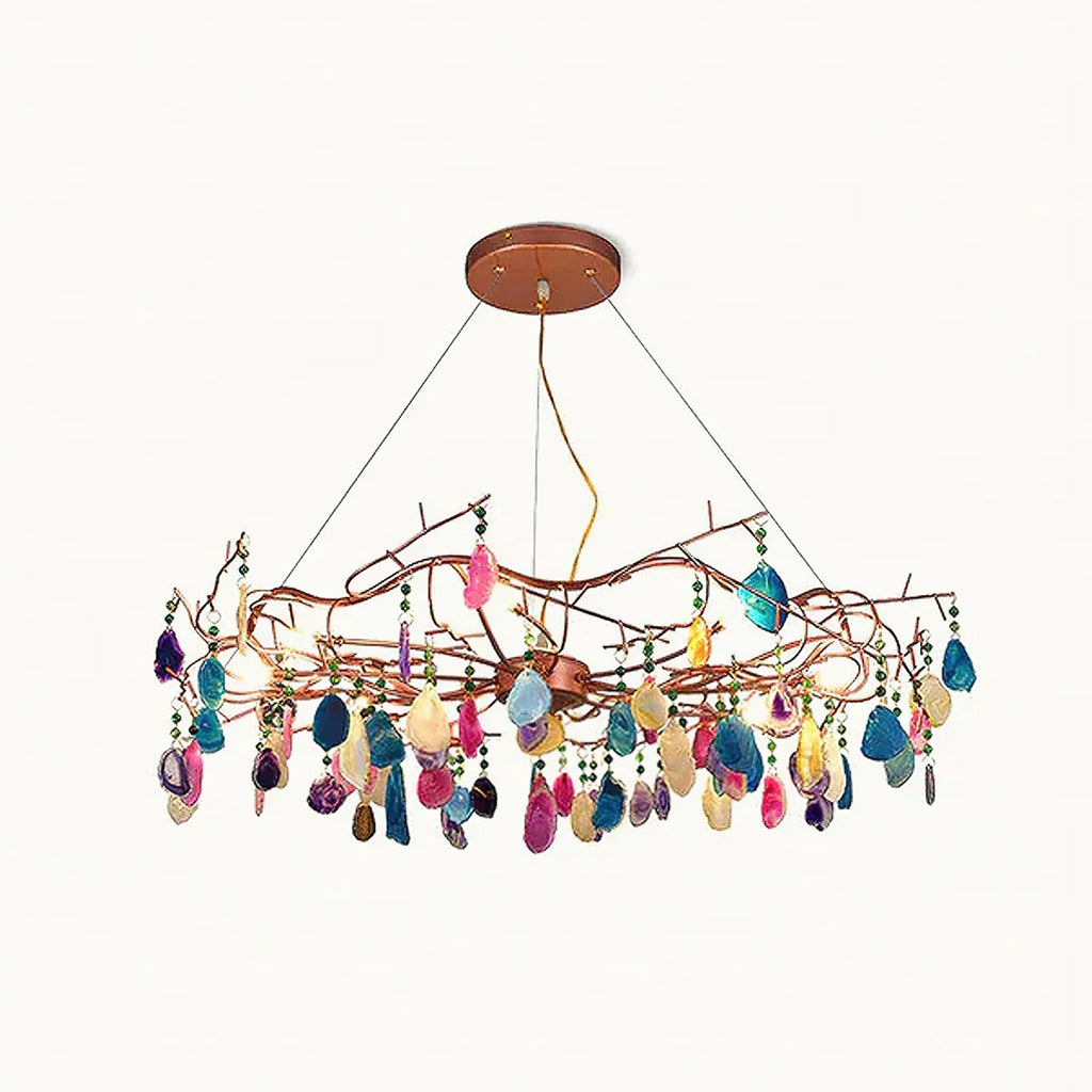 Clérachic agate chandelier with polished multicoloured stone slices hanging from a twisting rose-gold branch frame, on a plain white backdrop.