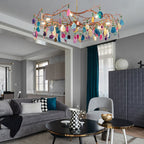 Multicolour Clérachic agate chandelier hanging high in a grey living room, above a dark coffee table and a blue-grey sofa.