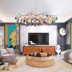 Clérachic agate chandelier of mixed-colour stone slices in a large living room, above a round coffee table and an orange cabinet.