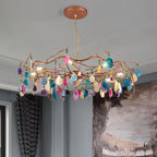 Close view of the stone slices and the rose-gold branches on this Clérachic agate chandelier, against a grey wall and a mural.
