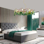 Green-slice Clérachic agate chandelier hanging in a bedroom with a grey tufted bed, a green throw and tall green curtains.